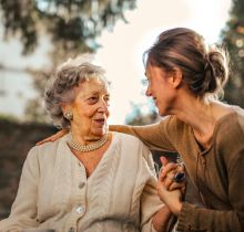 Joyful adult daughter greeting happy surprised senior mother in garden